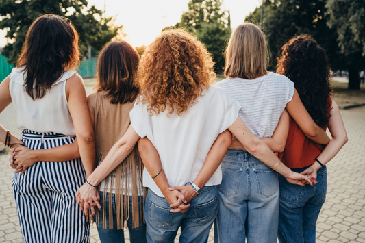 Mehrere Frauen stehen nebeneinander und halten sich an den Händen