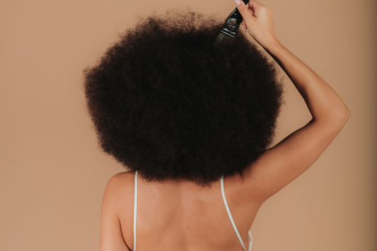 Eine Frau mit Afrofrisur kämmt sich die Haare
