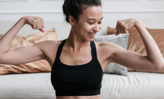 Eine Frau spannt ihre Armmuskeln an Fitness Sport