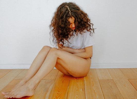 Eine Frau mit Bauchschmerzen hält sich den Bauch