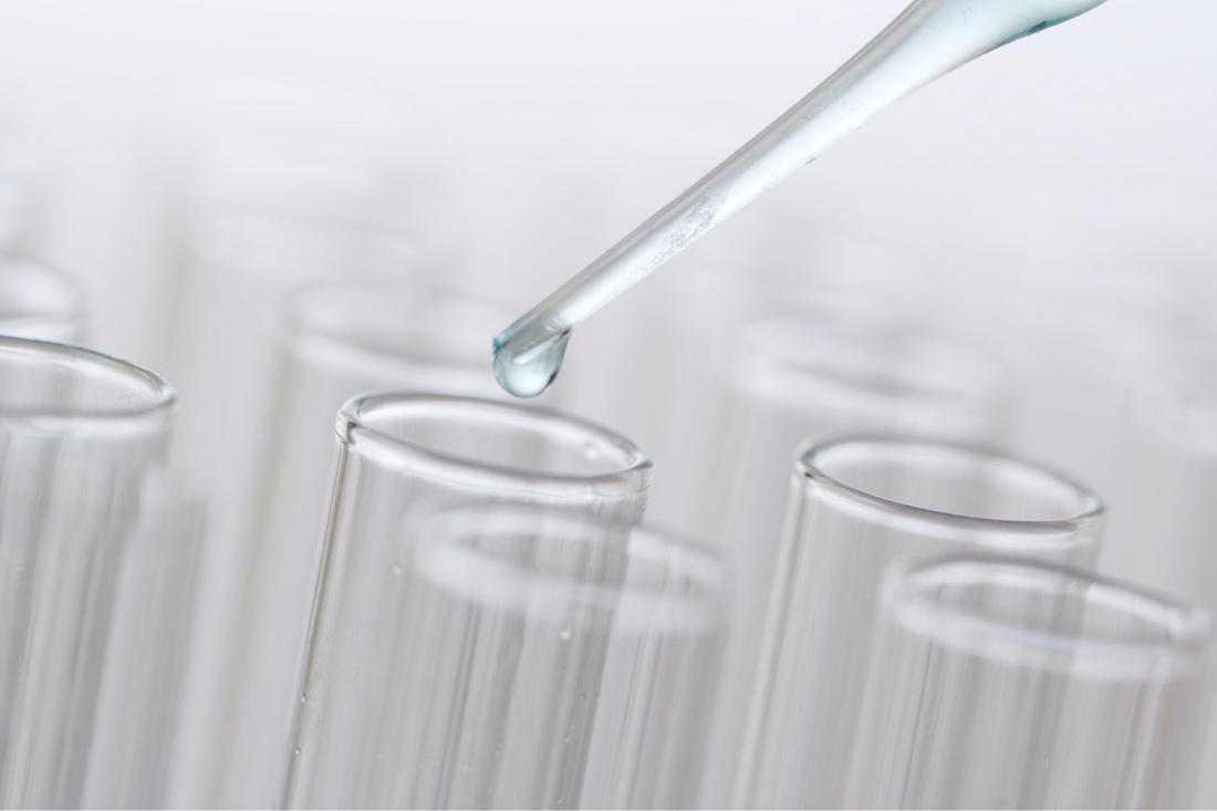 Eine Pipette führt Flüssigkeit in ein Glasröhrchen ein Forschung