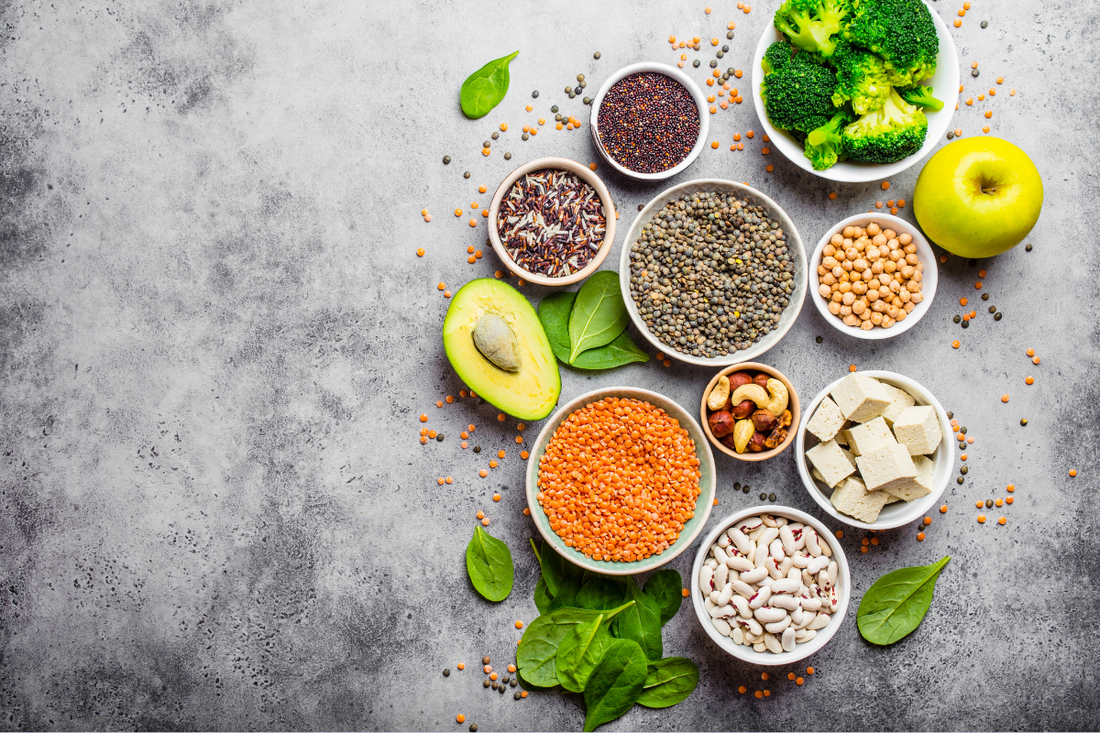 Verschiedenes Obst, Gemüse, Tofu, Nüsse und Samen stehen auf einem Tisch