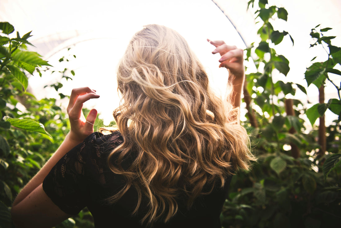 Eine Frau mit langem blondem Haar läuft durch die Natur